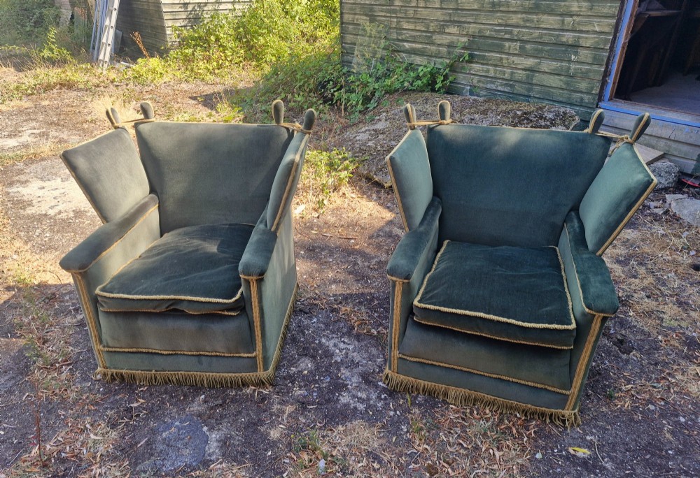 A pair of olive green velvet Knole armchairs featuring drop-side arms with finial ties, gold piping, and lower fringe trim. View II