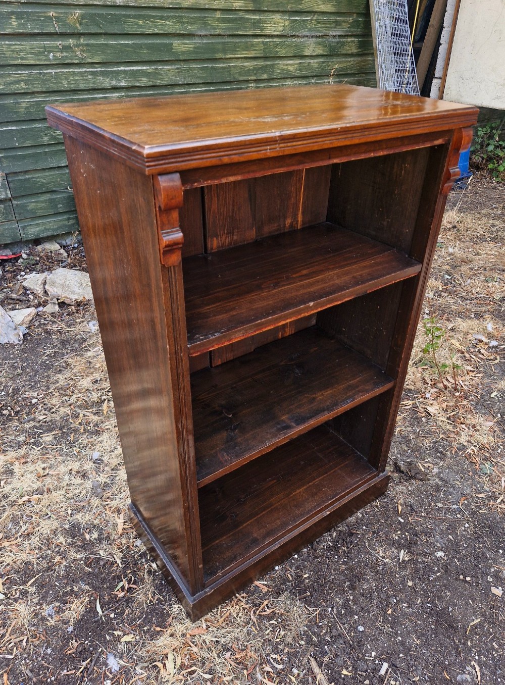 A small late Victorian dark walnut open bookcase with carved corner corbels, three shelf compartments, and a solid plinth base. View III
