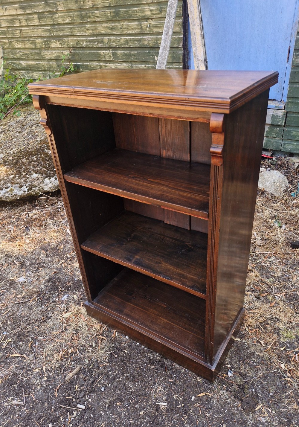 A small late Victorian dark walnut open bookcase with carved corner corbels, three shelf compartments, and a solid plinth base. View IV