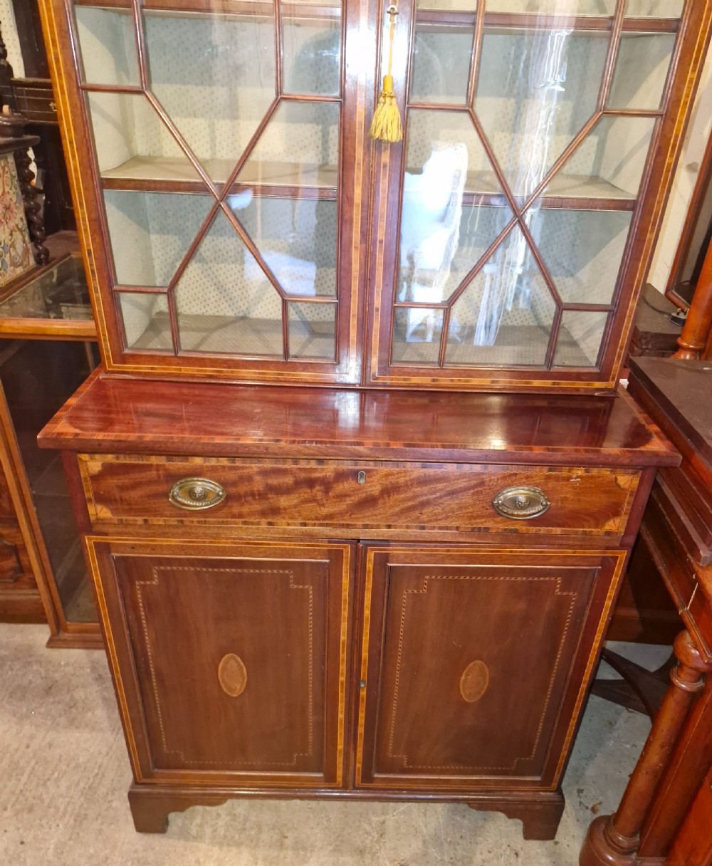 A 19th-century two-tier mahogany bookcase cabinet featuring astragal glazed upper doors, a single long drawer, and inlaid double lower doors on bracket feet. View II