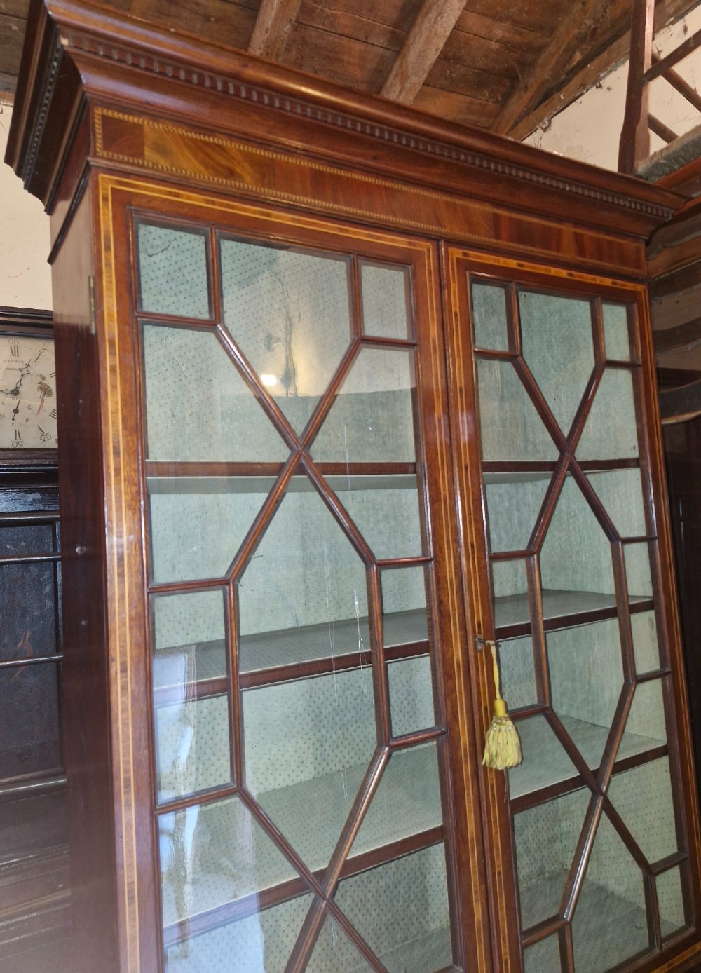 A 19th-century two-tier mahogany bookcase cabinet featuring astragal glazed upper doors, a single long drawer, and inlaid double lower doors on bracket feet. View VI