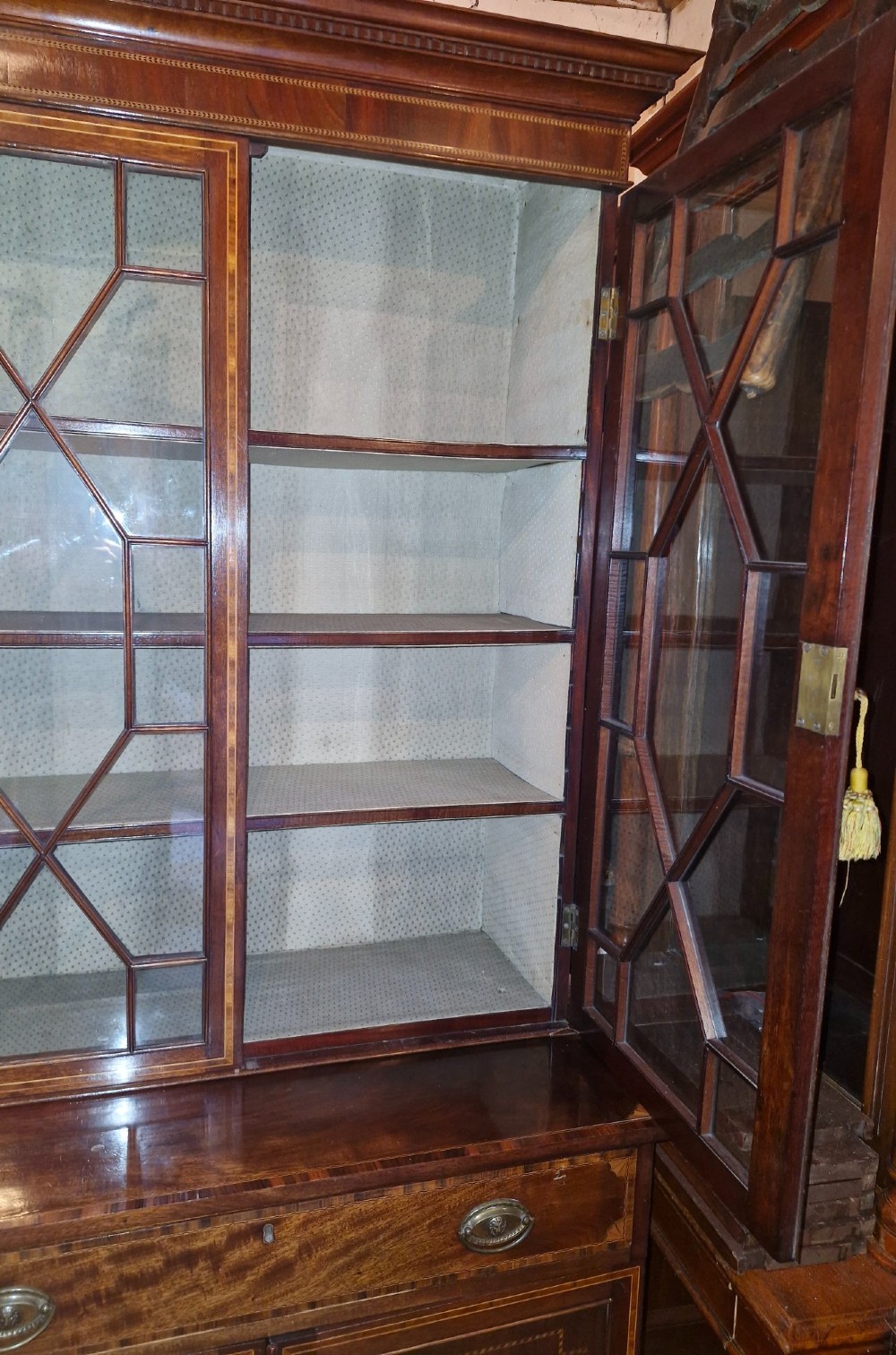 A 19th-century two-tier mahogany bookcase cabinet featuring astragal glazed upper doors, a single long drawer, and inlaid double lower doors on bracket feet. View VIII