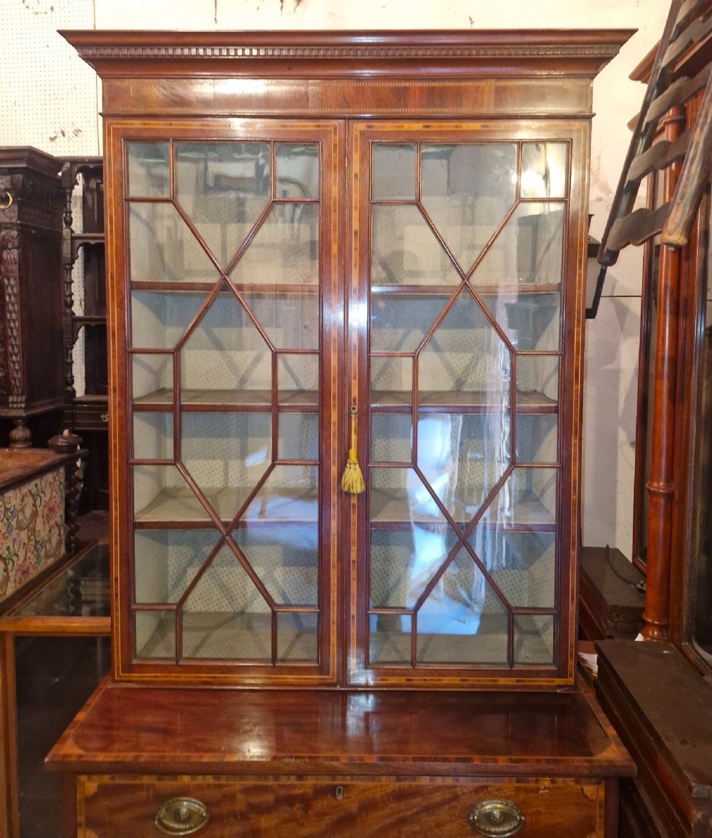 A 19th-century two-tier mahogany bookcase cabinet featuring astragal glazed upper doors, a single long drawer, and inlaid double lower doors on bracket feet. View IX
