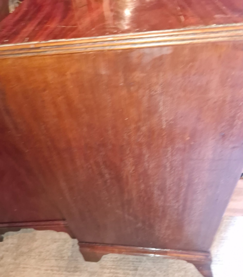An early nineteenth-century mahogany chest of drawers featuring four graduated drawers with turned wooden knobs and bracket feet. View VIII