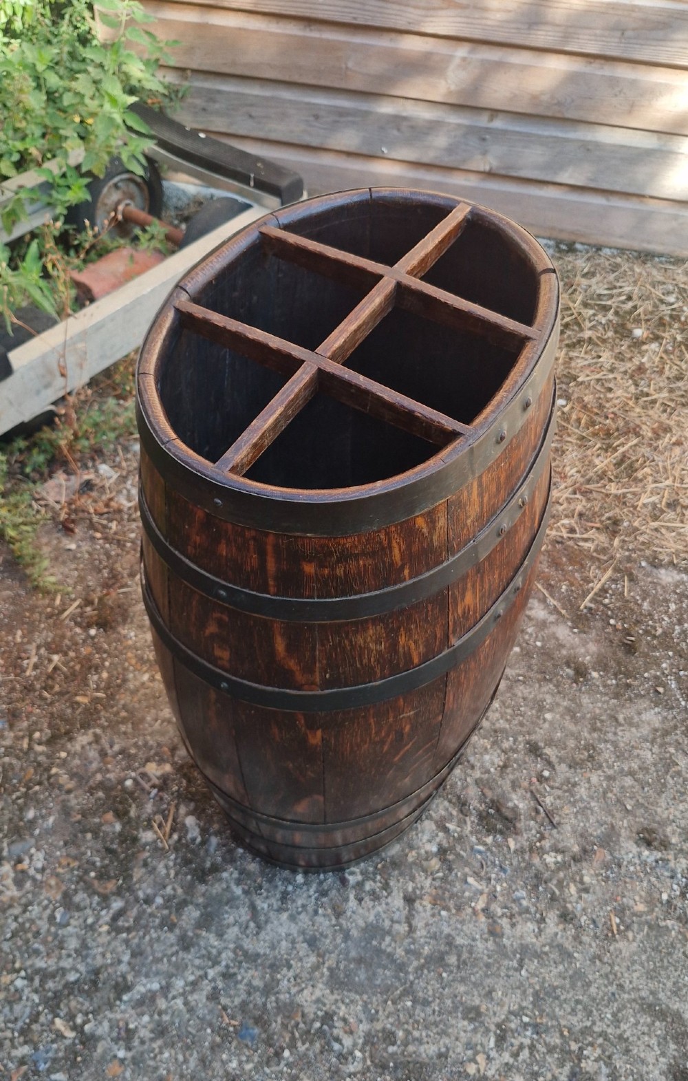 A dark oak coopered barrel stick stand featuring metal binding hoops and a six-section wood divider at the top. View III