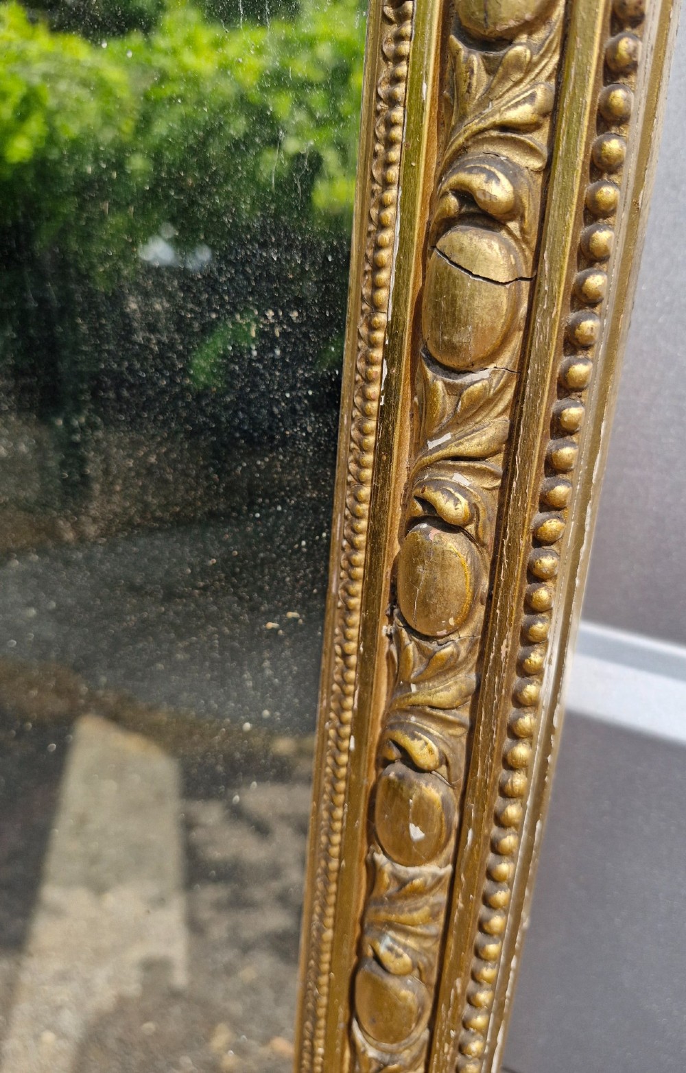 A tall Victorian mirror featuring an arched giltwood frame decorated with bead moulding and an ornate cresting motif at the top. View II