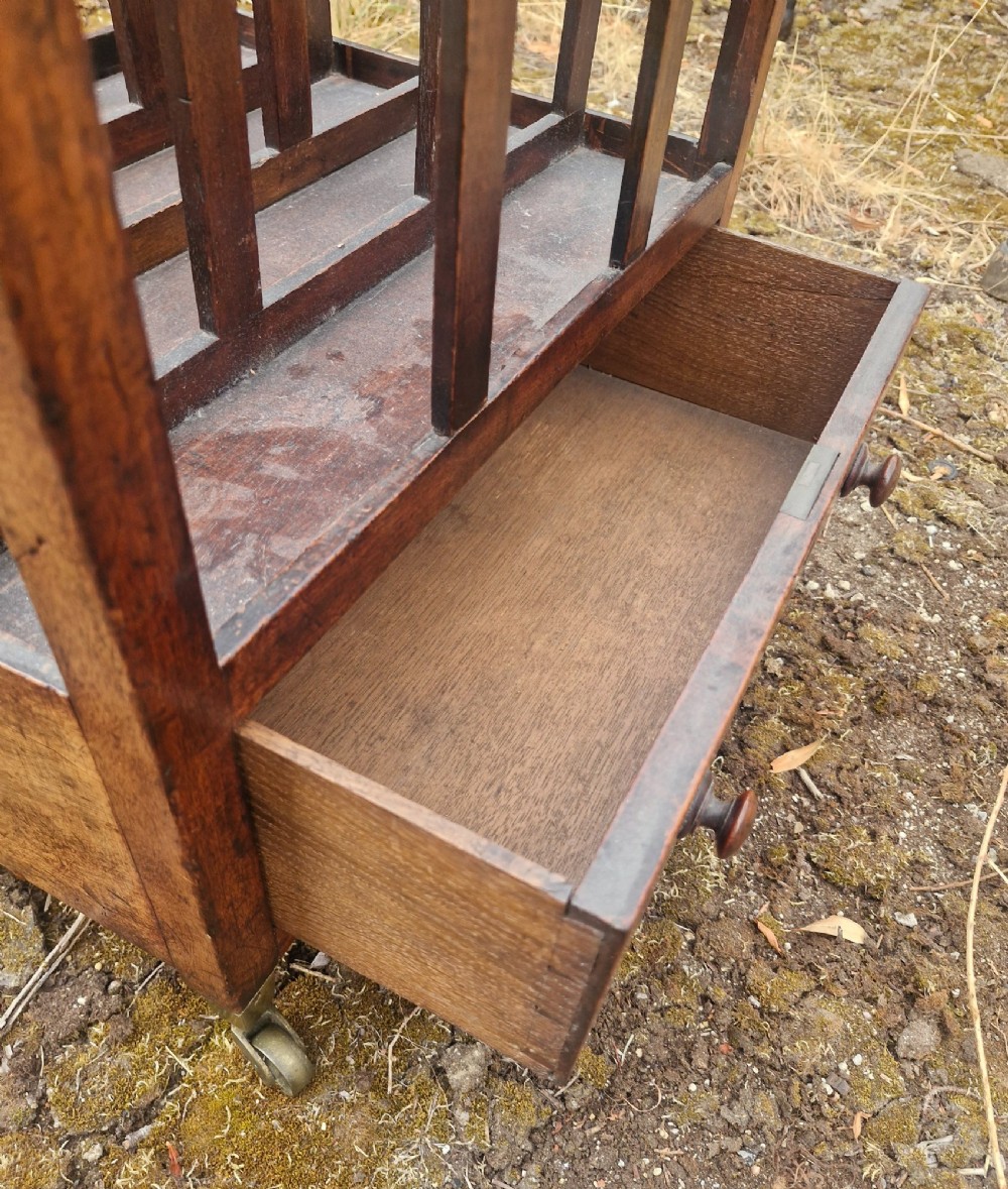 A Regency mahogany Canterbury with slatted music divisions, an integrated handle cut-out, a single base drawer, and brass castors. View II