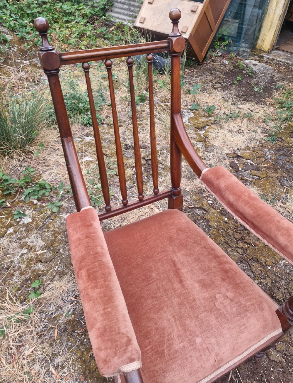 An early Victorian mahogany armchair featuring a spindle backrest, padded velvet armrests, a cushioned brown velvet seat, and turned wooden front legs. View II