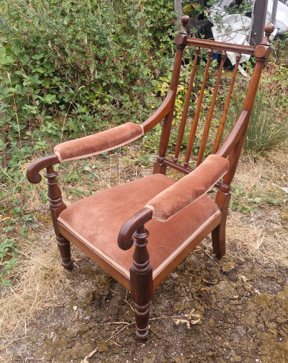 An early Victorian mahogany armchair featuring a spindle backrest, padded velvet armrests, a cushioned brown velvet seat, and turned wooden front legs. View IV