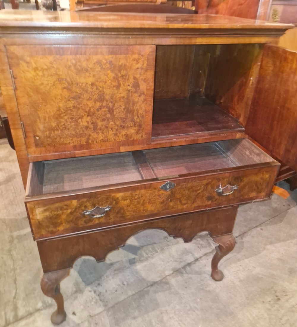 An early 20th-century burr walnut cabinet chest featuring twin upper doors over two drawers, resting on a shaped apron with carved cabriole legs. View II