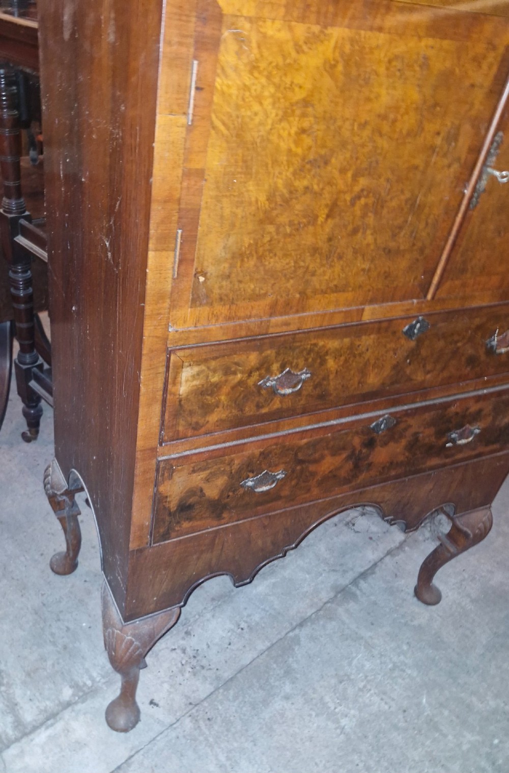 An early 20th-century burr walnut cabinet chest featuring twin upper doors over two drawers, resting on a shaped apron with carved cabriole legs. View III