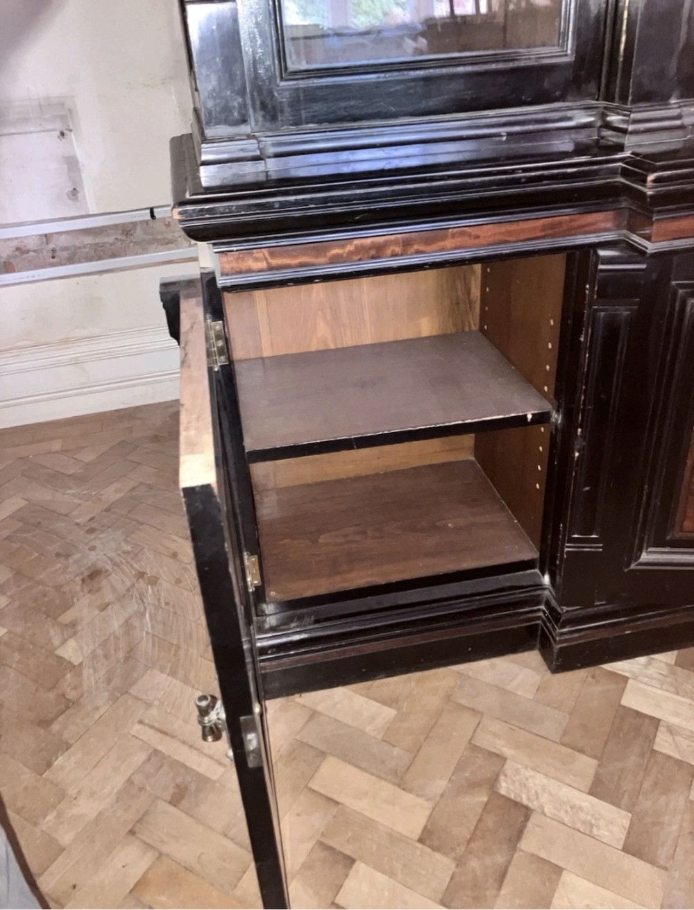 A large Victorian ebonised and mahogany breakfront library bookcase featuring glazed upper doors, panelled lower cupboards, and fluted side pilasters. View VI