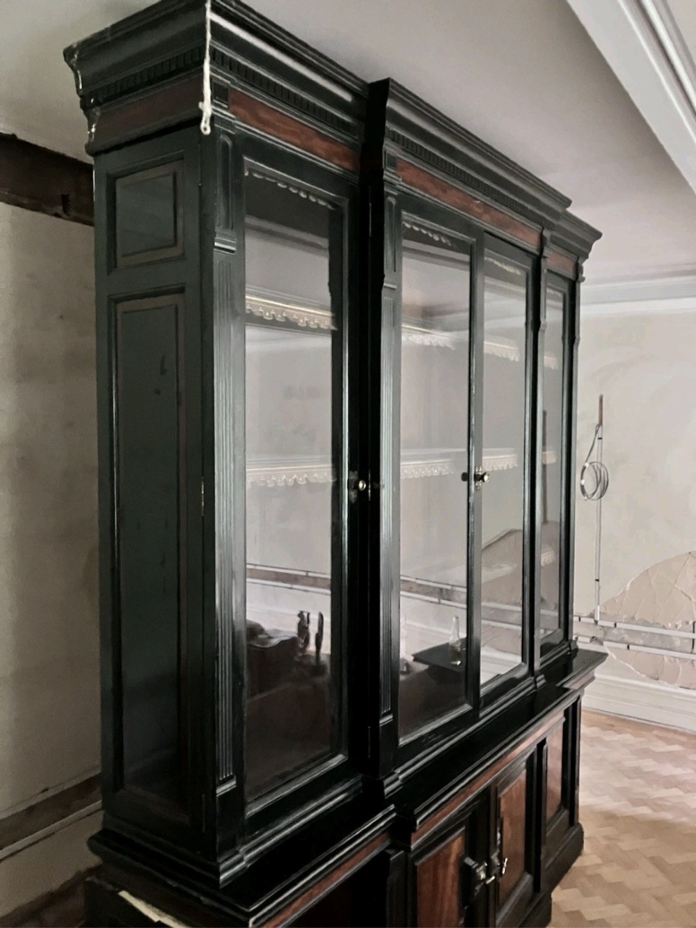 A large Victorian ebonised and mahogany breakfront library bookcase featuring glazed upper doors, panelled lower cupboards, and fluted side pilasters. View VIII