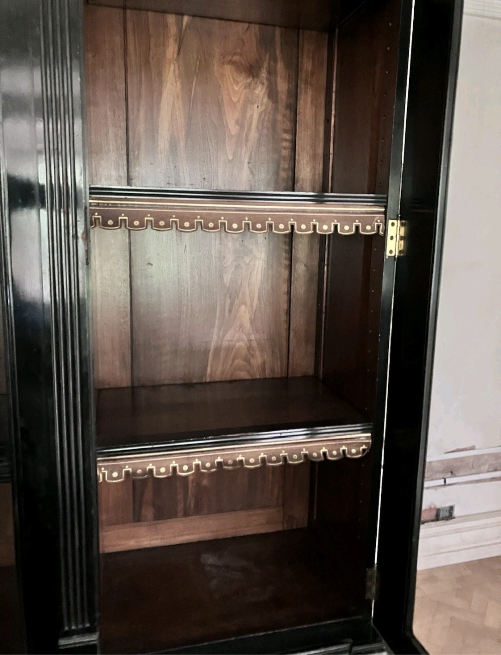 A large Victorian ebonised and mahogany breakfront library bookcase featuring glazed upper doors, panelled lower cupboards, and fluted side pilasters. View IX