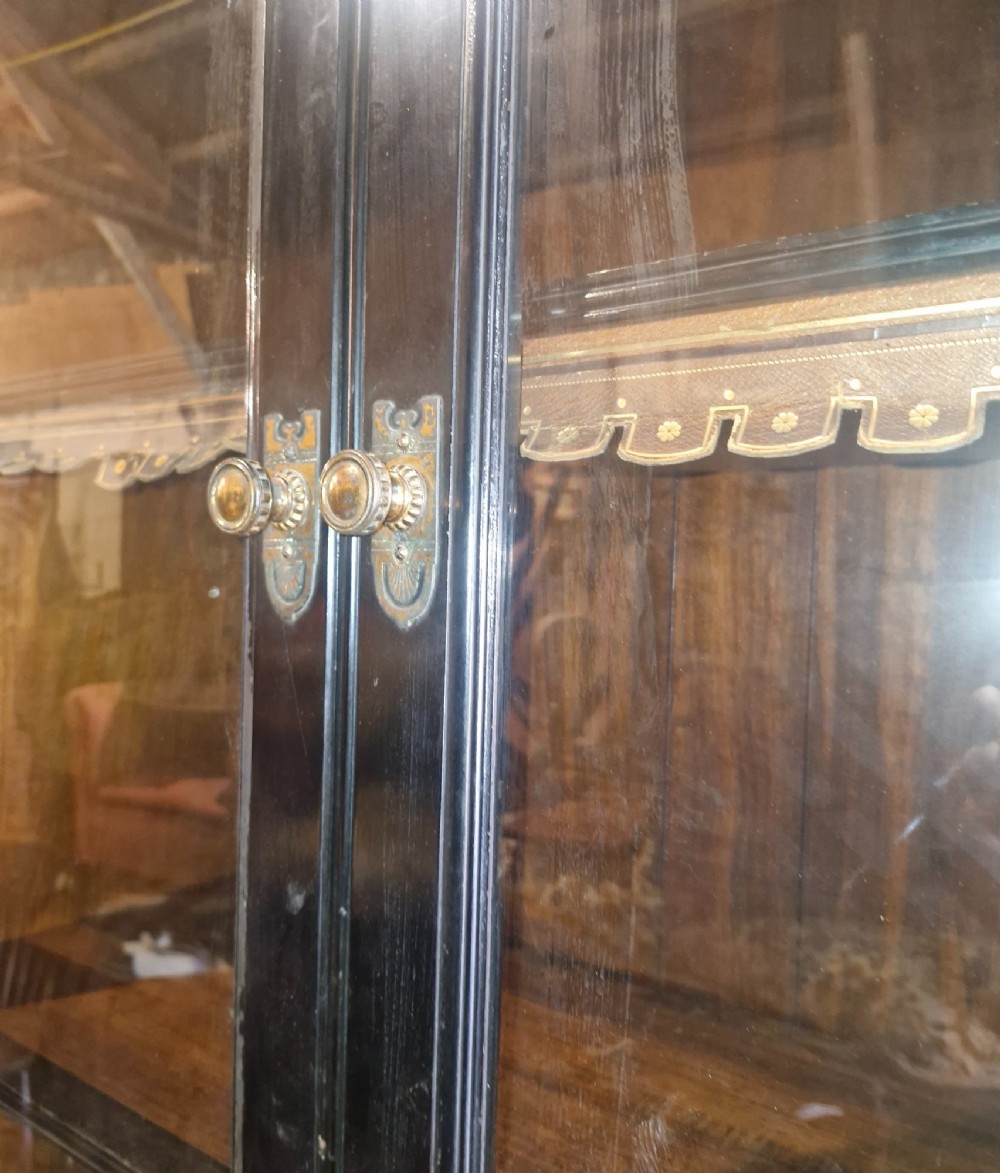 A large Victorian ebonised and mahogany breakfront library bookcase featuring glazed upper doors, panelled lower cupboards, and fluted side pilasters. View XIII