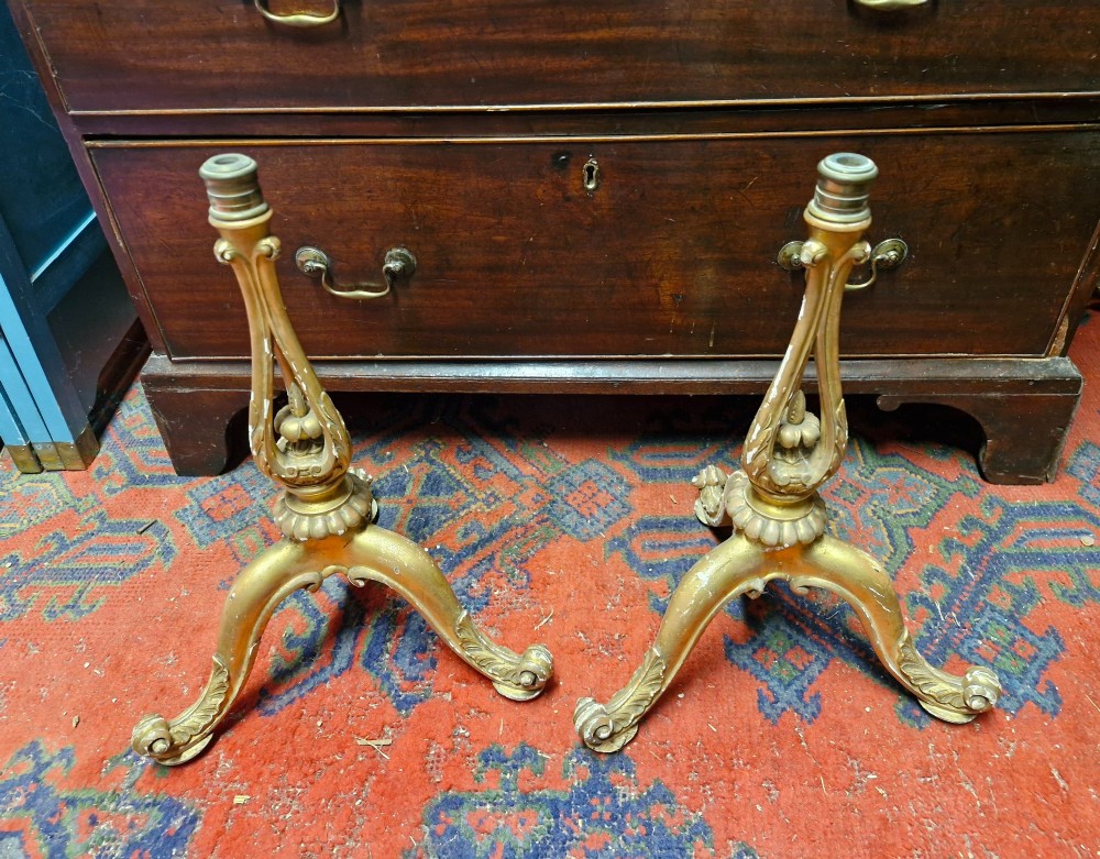 A pair of carved wood tripod bases featuring aged gold leaf gilding, scrolled tripod legs, and acanthus leaf carving.