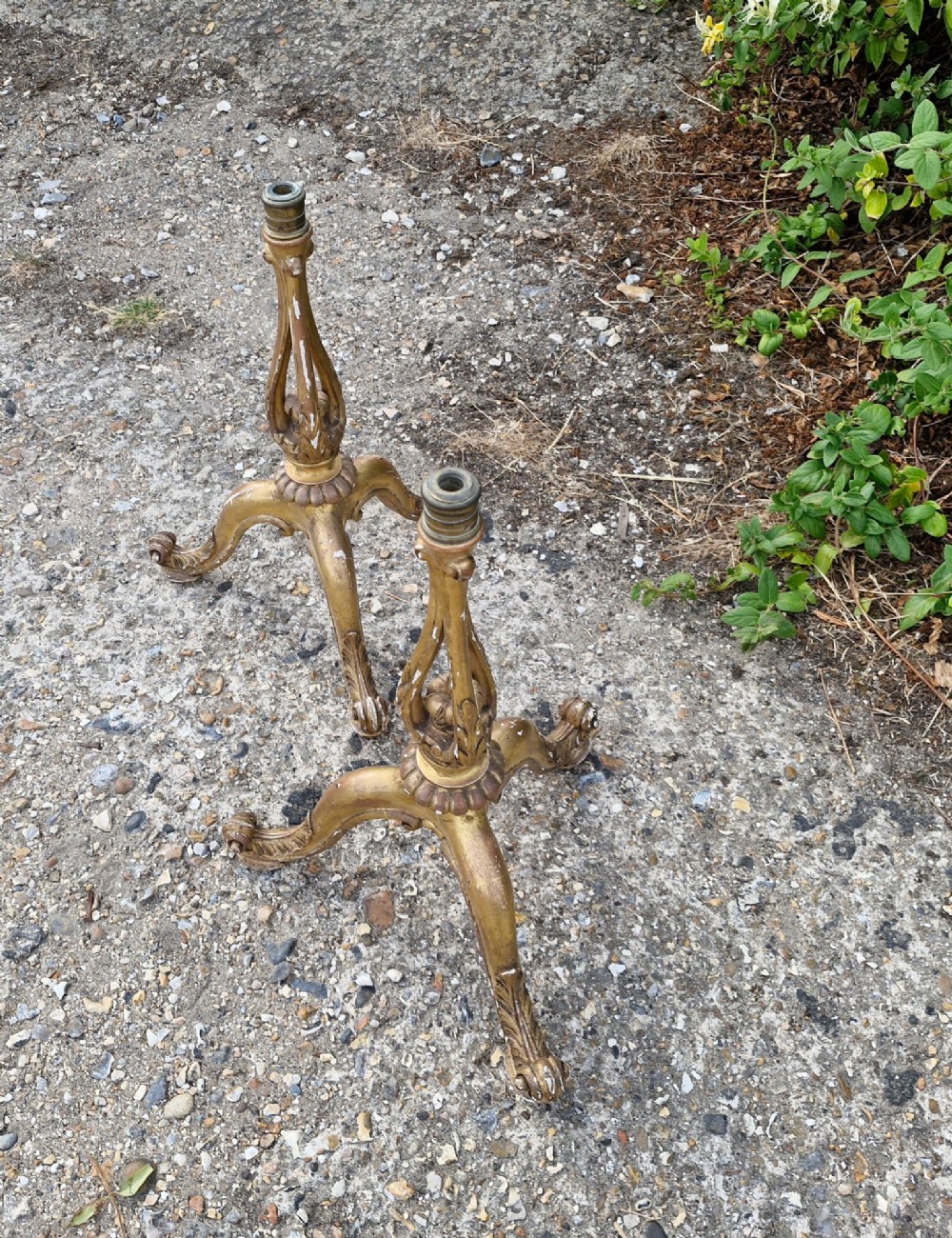 A pair of carved wood tripod bases featuring aged gold leaf gilding, scrolled tripod legs, and acanthus leaf carving. View IX