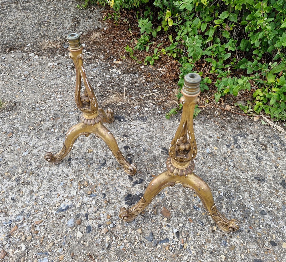 A pair of carved wood tripod bases featuring aged gold leaf gilding, scrolled tripod legs, and acanthus leaf carving. View X