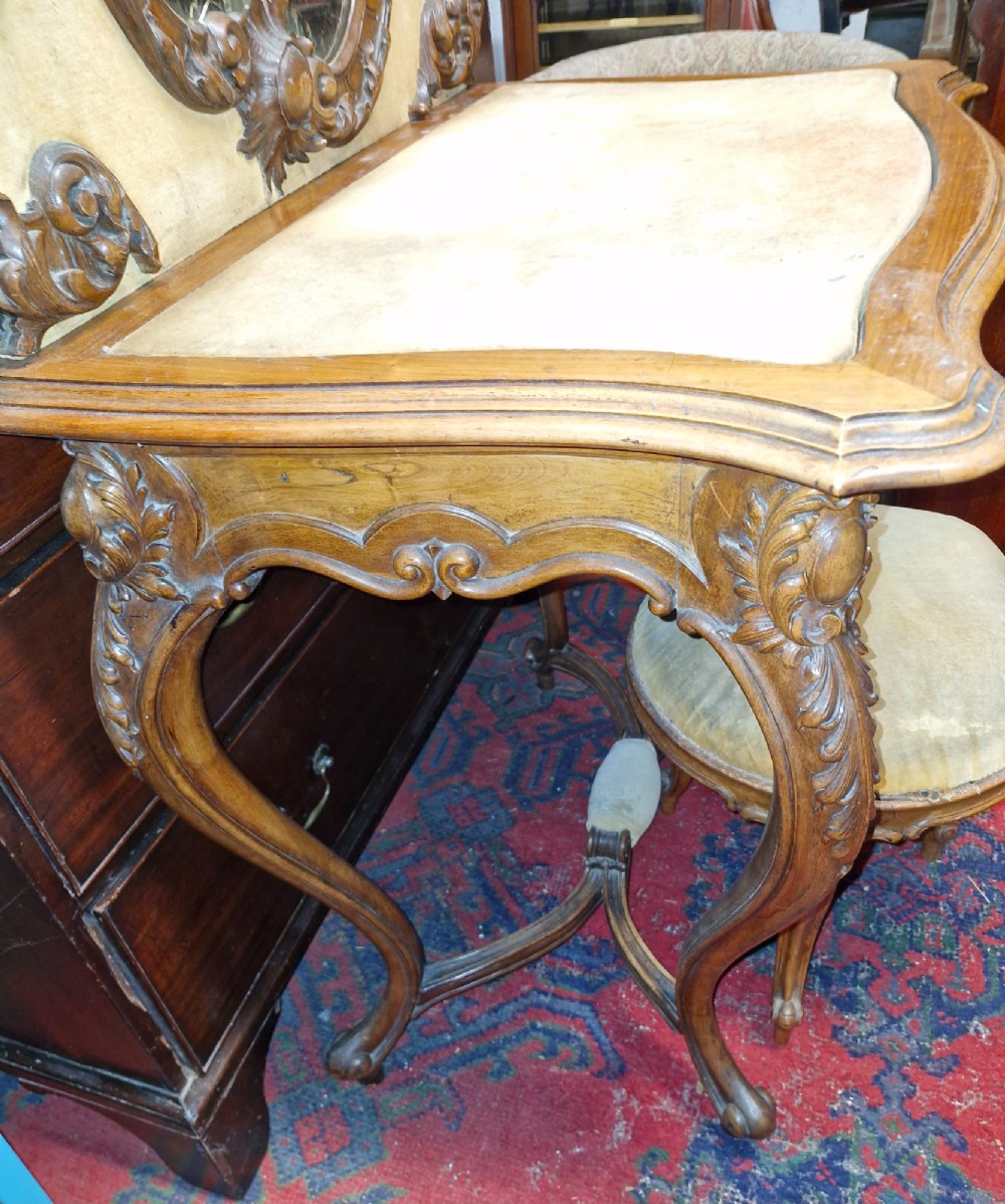 A French Rococo Revival carved walnut dressing table featuring an integrated oval mirror and a matching upholstered stool. View II