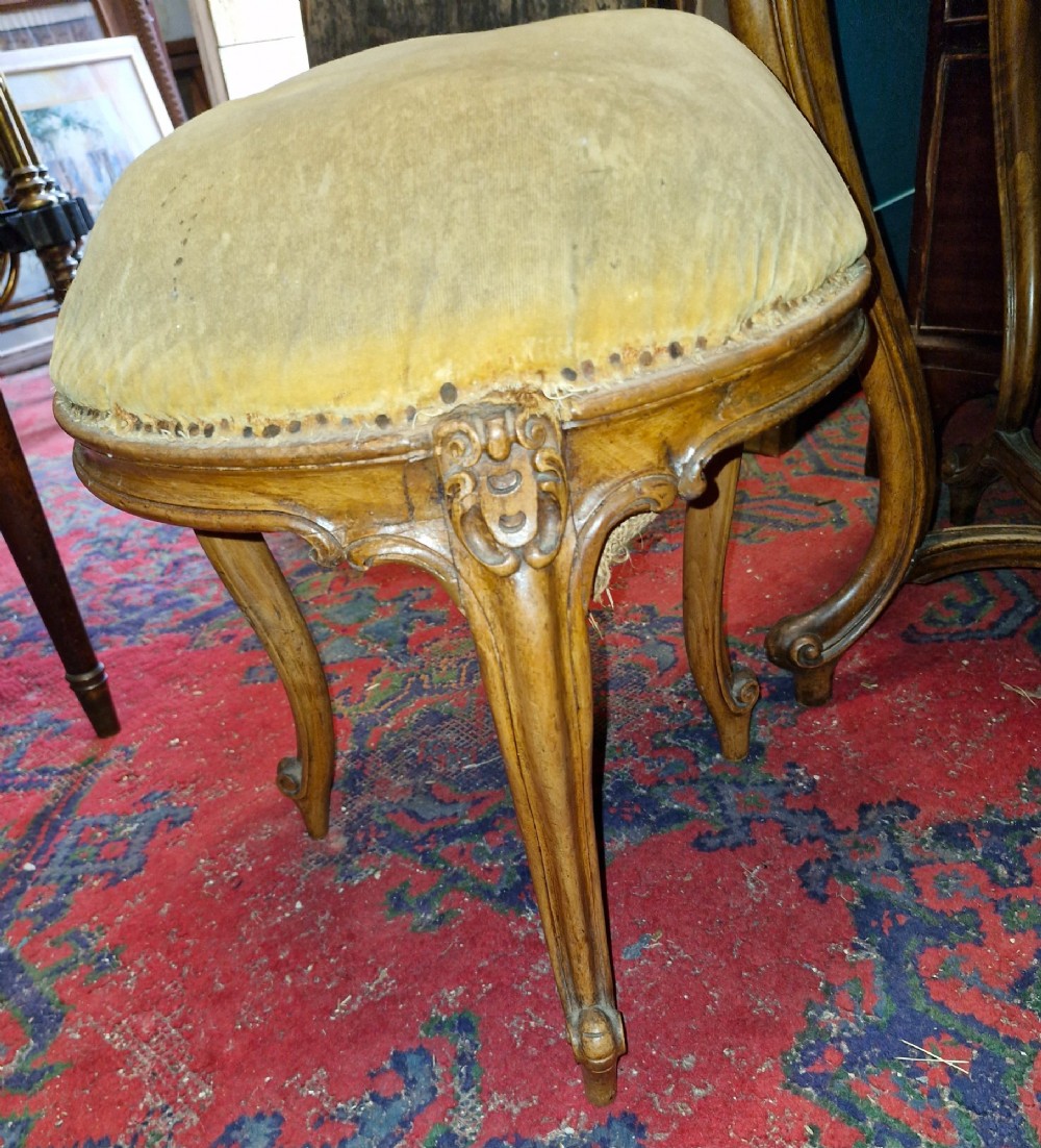 A French Rococo Revival carved walnut dressing table featuring an integrated oval mirror and a matching upholstered stool. View VII
