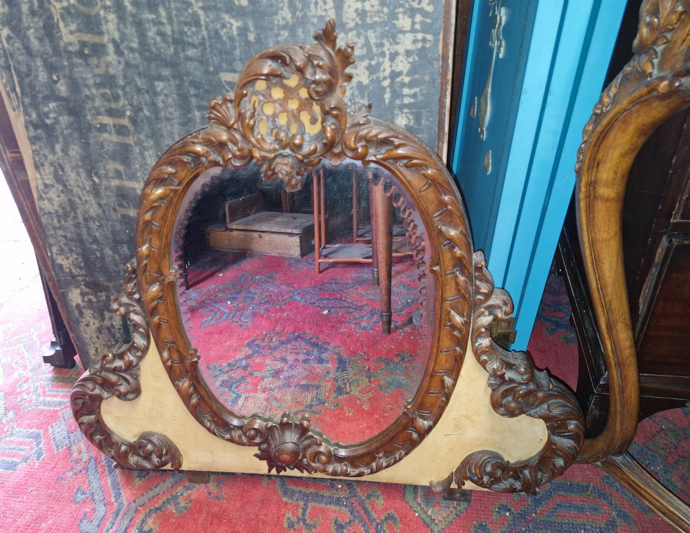 A French Rococo Revival carved walnut dressing table featuring an integrated oval mirror and a matching upholstered stool. View IX