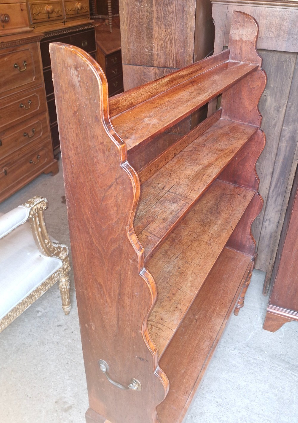 A 19th-century mahogany waterfall bookcase featuring four open graduated shelves, curved side profiles, and turned front legs. View IV