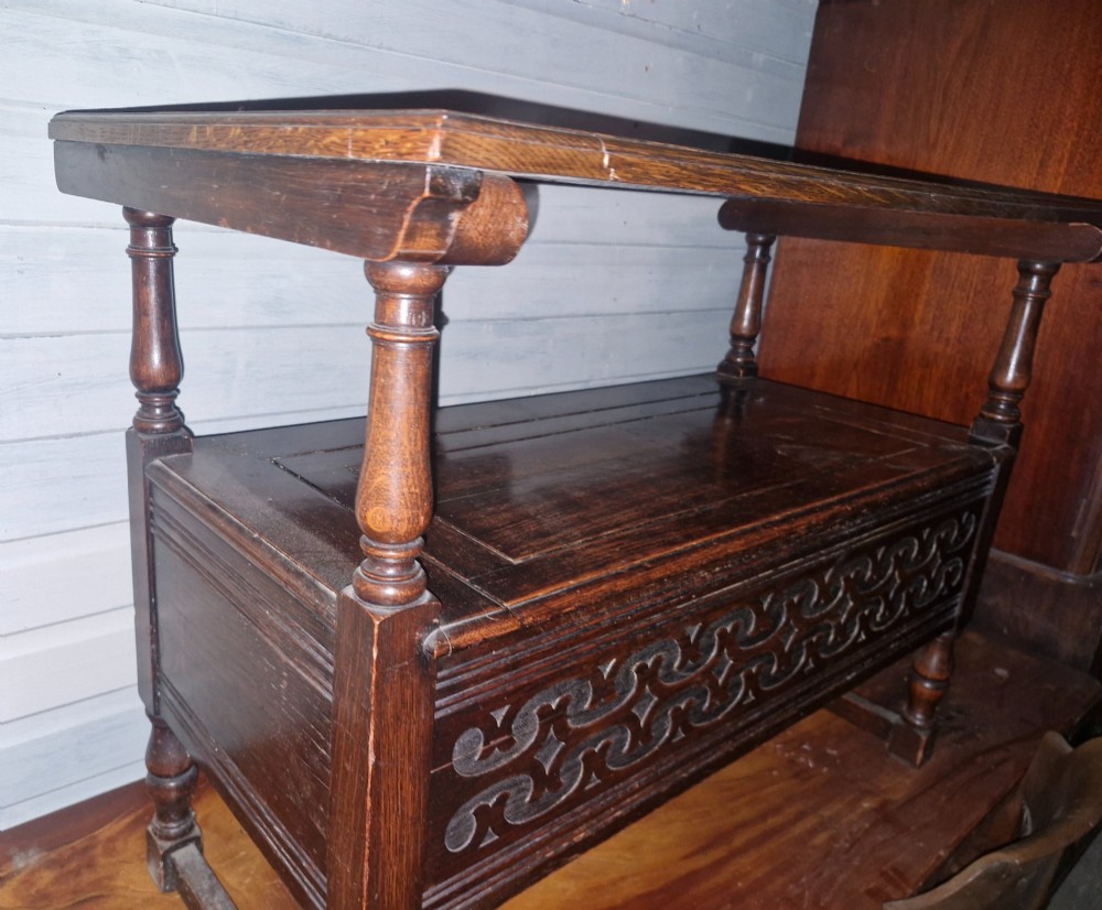 A dark oak monks bench featuring a carved diamond-patterned backrest, turned arm supports, carved front panel, and a lift-up seat. View VI