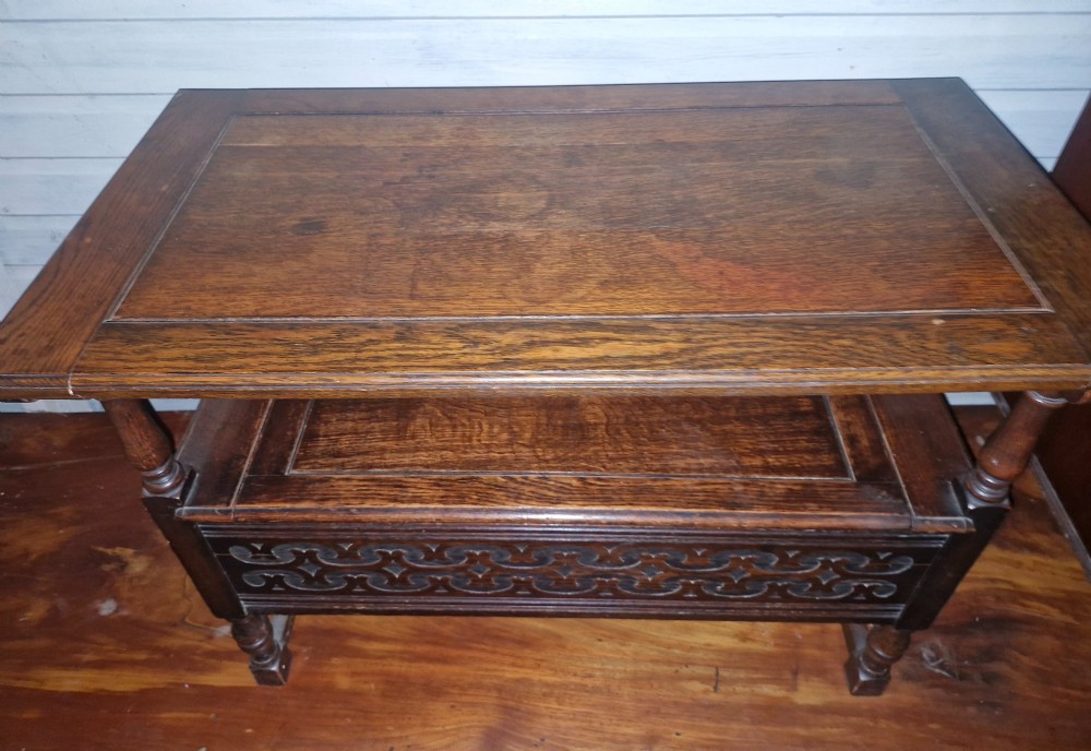 A dark oak monks bench featuring a carved diamond-patterned backrest, turned arm supports, carved front panel, and a lift-up seat. View VII