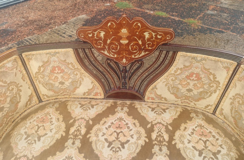 An Edwardian mahogany settee featuring central floral marquetry inlay, patterned damask upholstery, and cabriole legs. View II