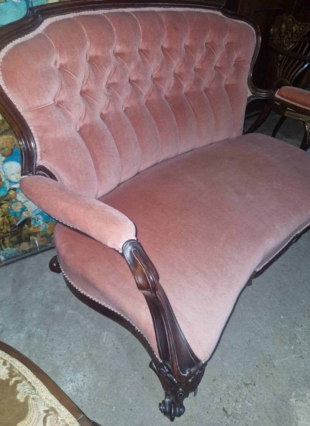 Mid-Victorian carved rosewood settee featuring button-tufted dusky pink velvet upholstery, serpentine backrest, and carved cabriole legs. View V