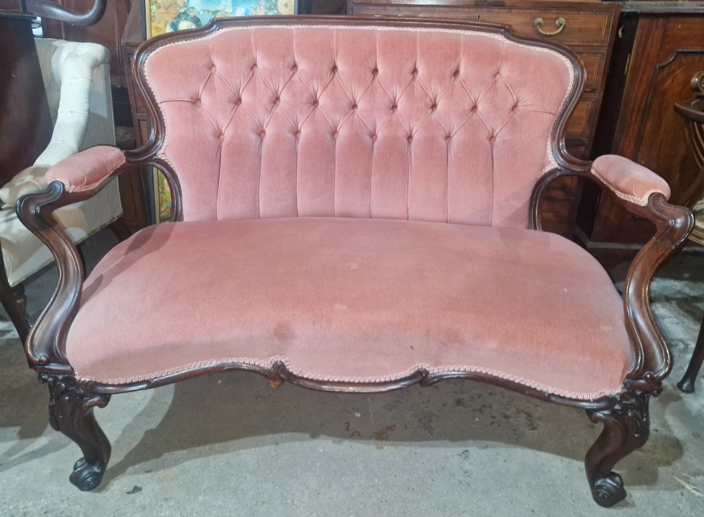 Mid-Victorian carved rosewood settee featuring button-tufted dusky pink velvet upholstery, serpentine backrest, and carved cabriole legs. View VII