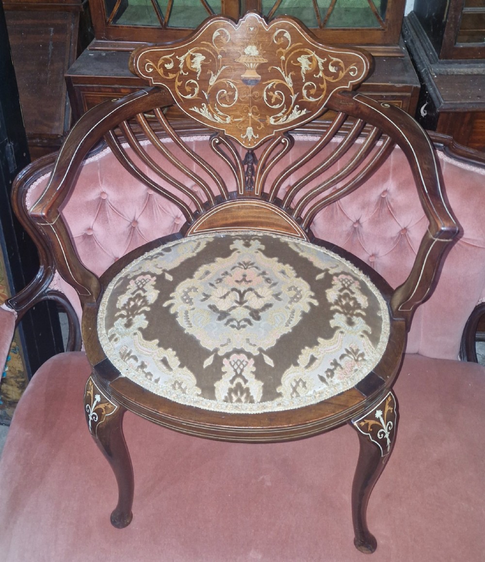 An Edwardian mahogany tub chair featuring floral marquetry inlay on the back splat, sweeping armrests, and an upholstered seat. View VI