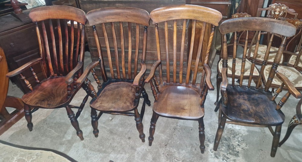 A set of four late Victorian wooden Windsor kitchen armchairs featuring spindle backs, shaped timber seats, turned legs, and stretchers. View XI