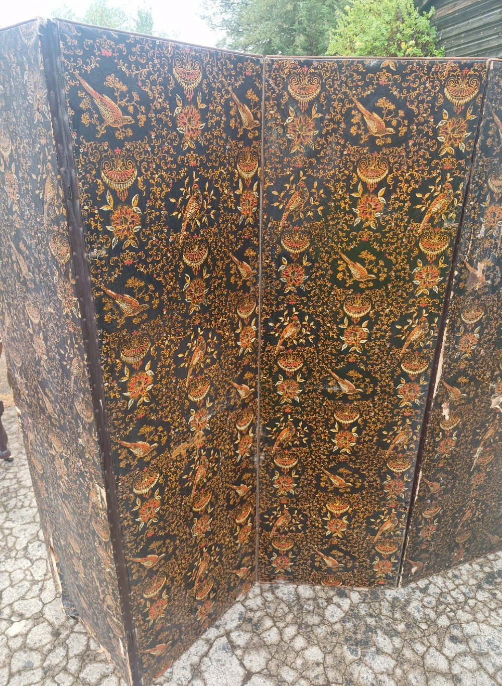 A late Victorian four-panel folding screen made of painted canvas featuring repeating golden bird and floral patterns on a dark black background. View II
