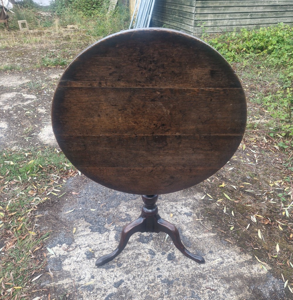 A dark oak 19th-century occasional table featuring a circular top tilted vertically on a turned pedestal with three cabriole legs. View V