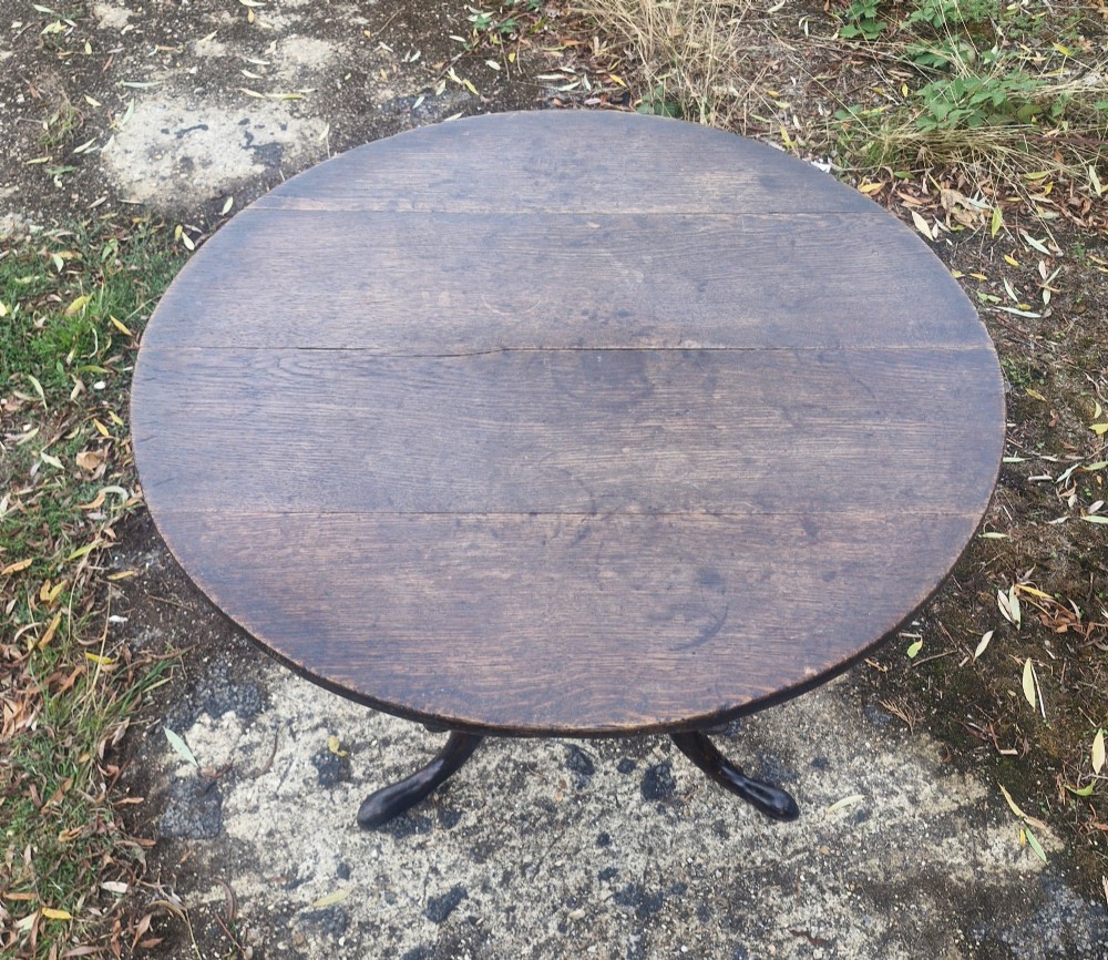 A dark oak 19th-century occasional table featuring a circular top tilted vertically on a turned pedestal with three cabriole legs. View VI