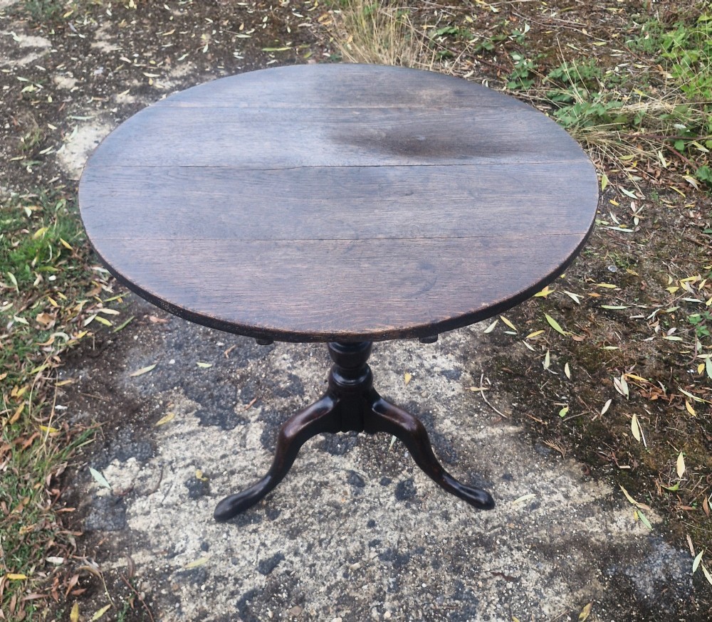 A dark oak 19th-century occasional table featuring a circular top tilted vertically on a turned pedestal with three cabriole legs. View VII