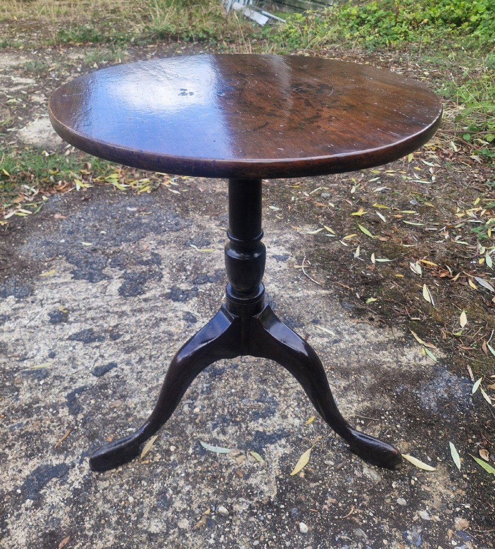 A Regency period mahogany occasional table featuring a circular top, turned central column stem, and three splayed legs. View II