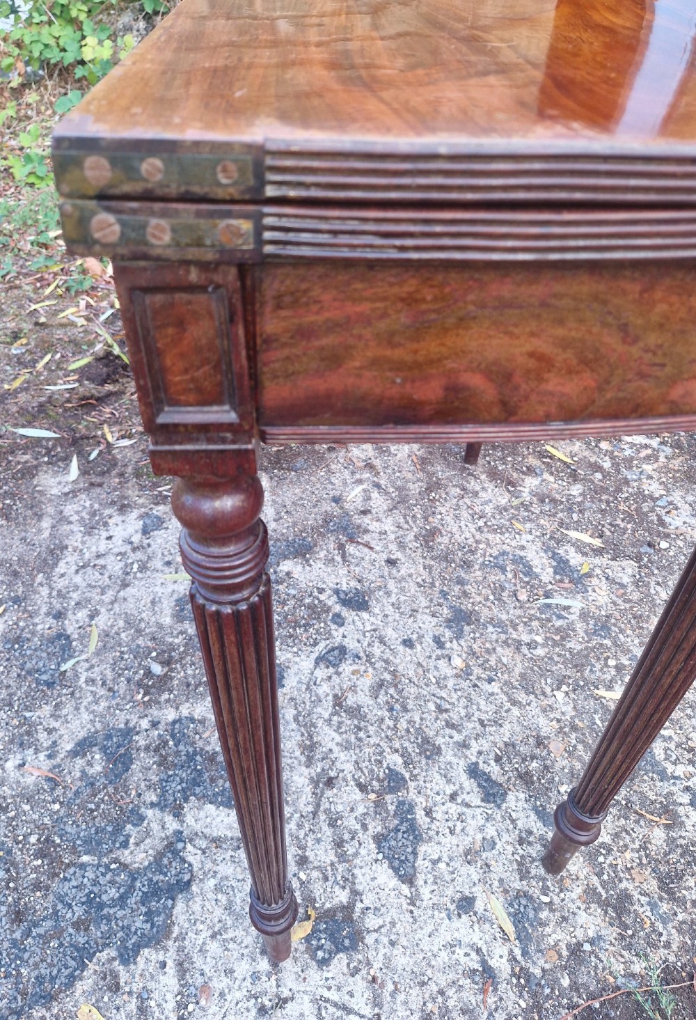 An early 19th-century mahogany demilune foldover tea table featuring a reeded apron and four reeded legs in the Gillows style. View II