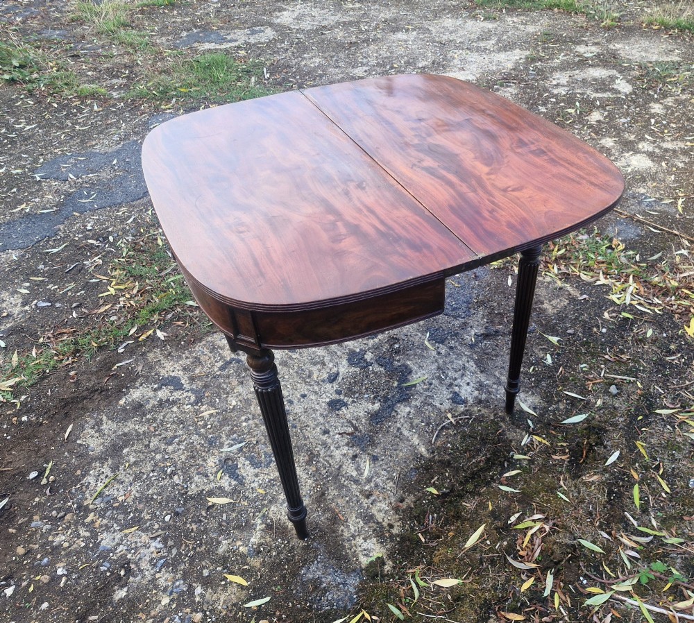 An early 19th-century mahogany demilune foldover tea table featuring a reeded apron and four reeded legs in the Gillows style. View III