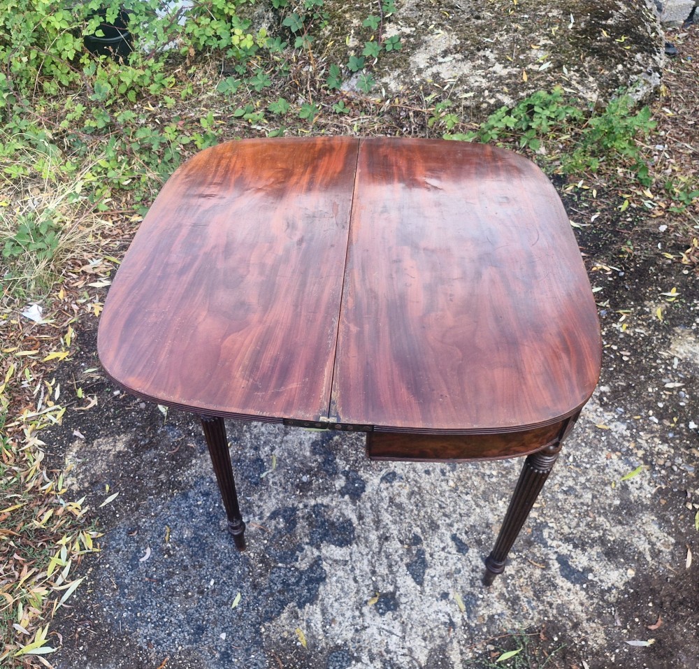 An early 19th-century mahogany demilune foldover tea table featuring a reeded apron and four reeded legs in the Gillows style. View IV