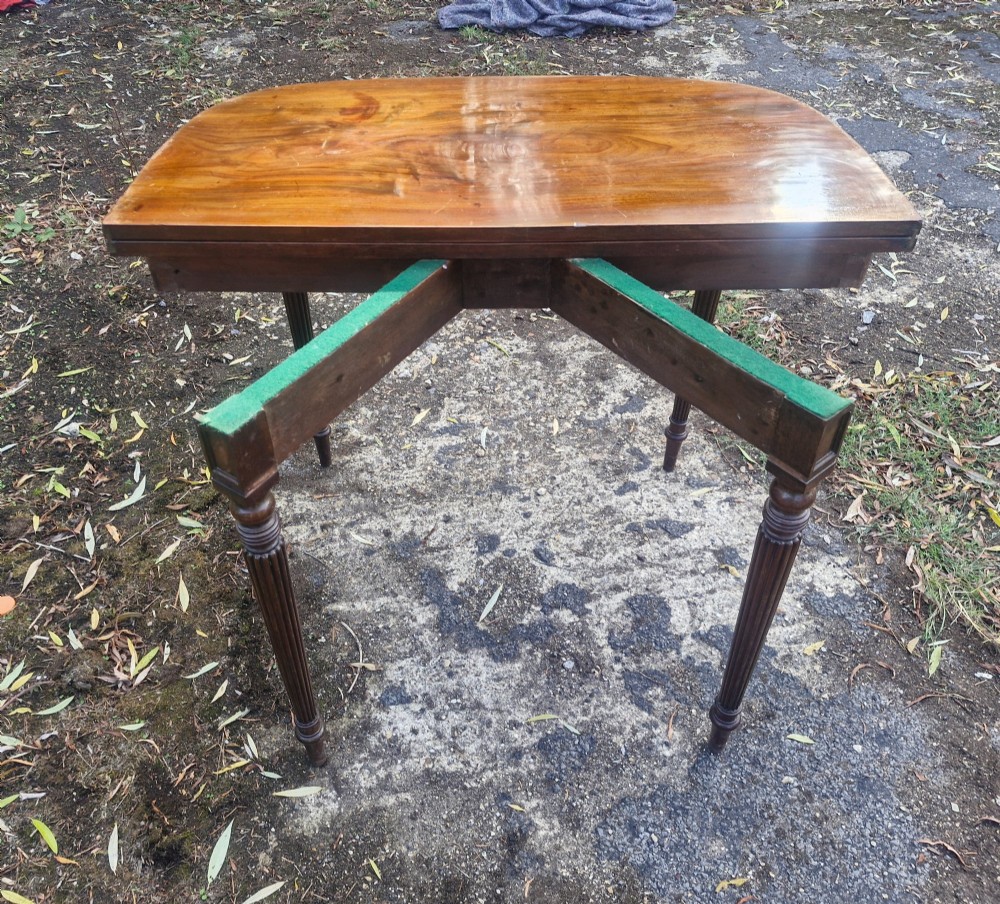 An early 19th-century mahogany demilune foldover tea table featuring a reeded apron and four reeded legs in the Gillows style. View VII