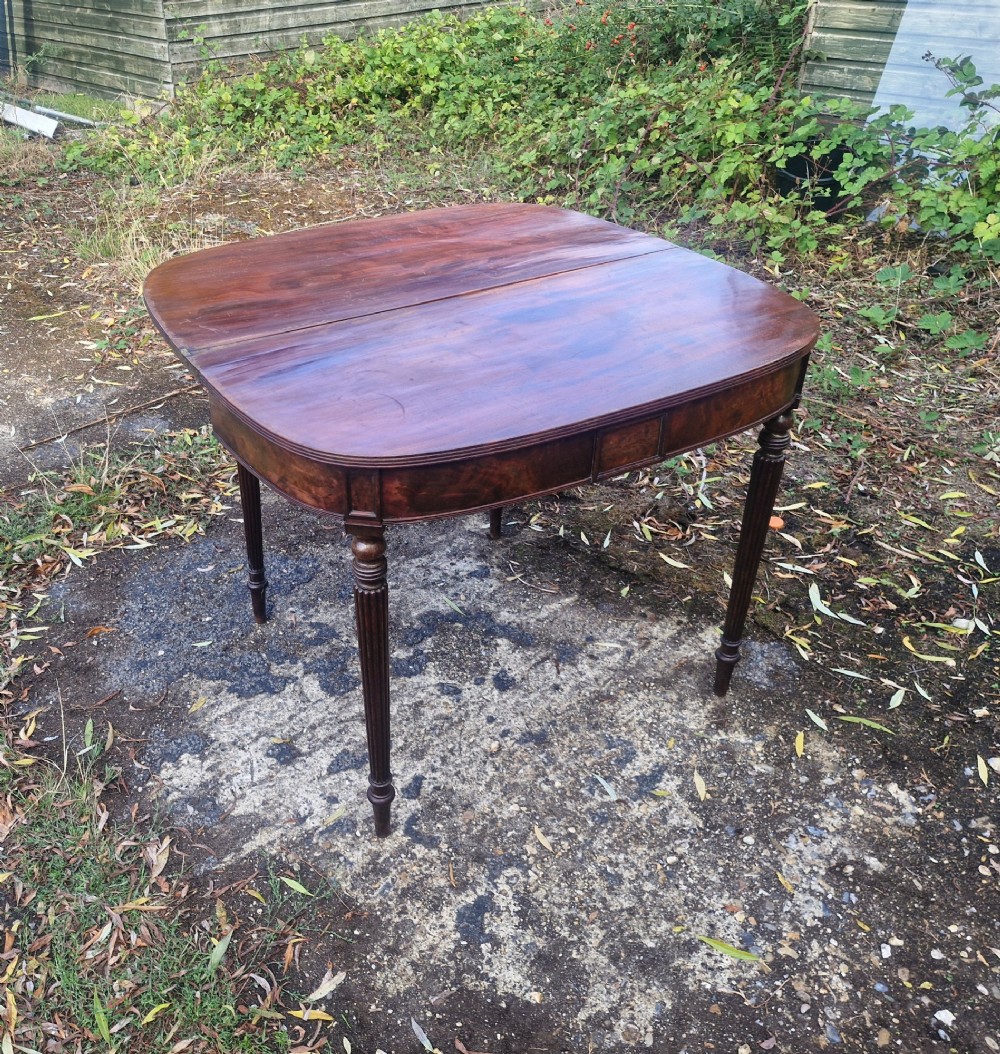 An early 19th-century mahogany demilune foldover tea table featuring a reeded apron and four reeded legs in the Gillows style. View VIII
