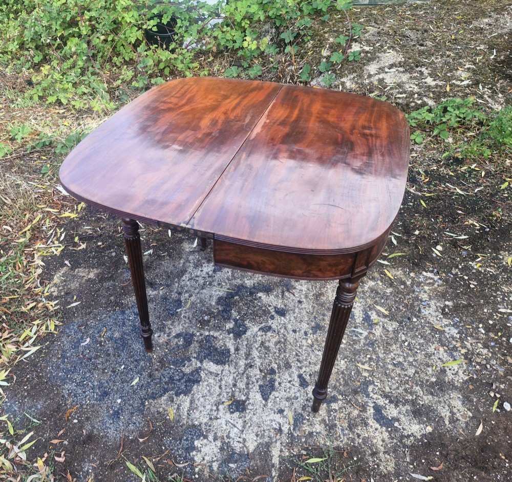 An early 19th-century mahogany demilune foldover tea table featuring a reeded apron and four reeded legs in the Gillows style. View IX