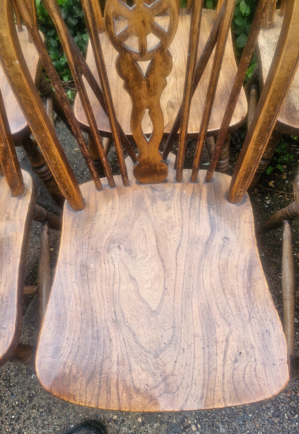 A set of six wooden Windsor dining chairs featuring hoop backs, wheelback splats, shaped solid seats, and turned legs. View II