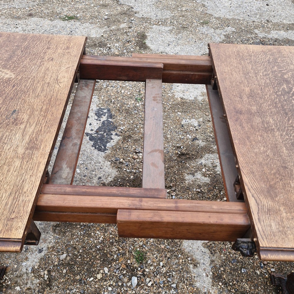 A late Victorian oak extending dining table featuring removable extension leaves, carved aprons, and turned legs. View II