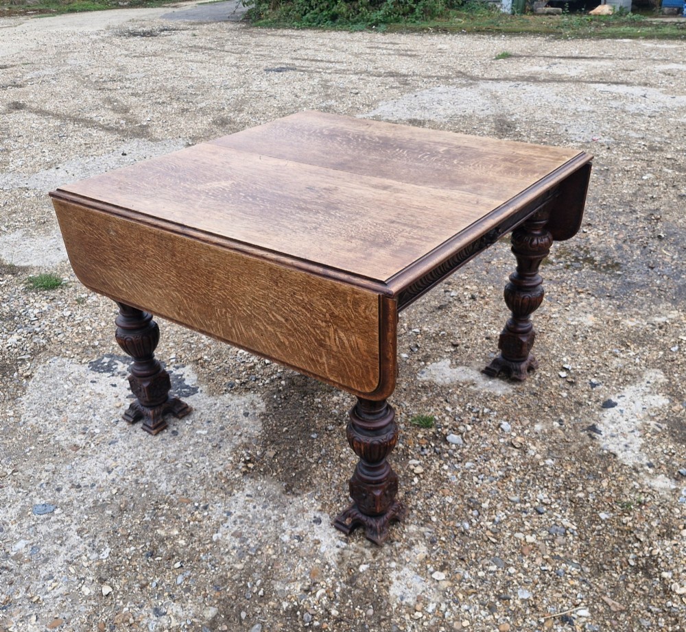A late Victorian oak extending dining table featuring removable extension leaves, carved aprons, and turned legs. View IV