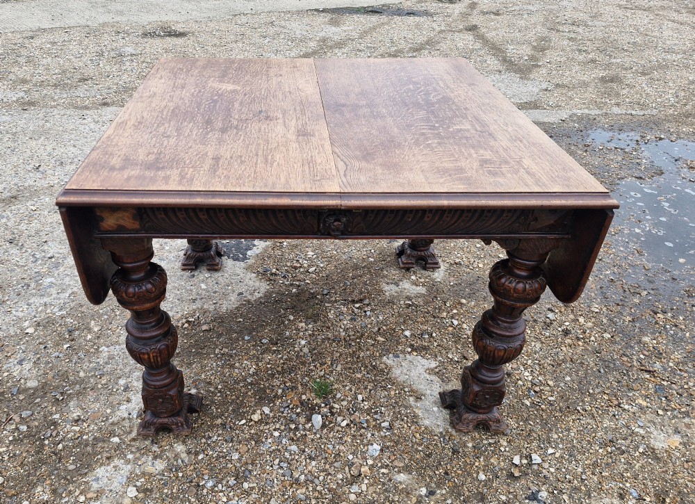 A late Victorian oak extending dining table featuring removable extension leaves, carved aprons, and turned legs. View VIII