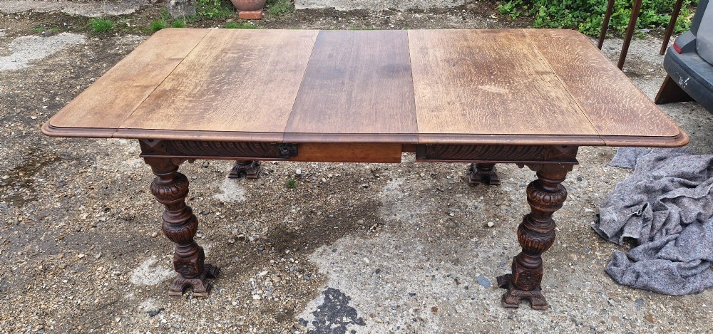 A late Victorian oak extending dining table featuring removable extension leaves, carved aprons, and turned legs. View IX