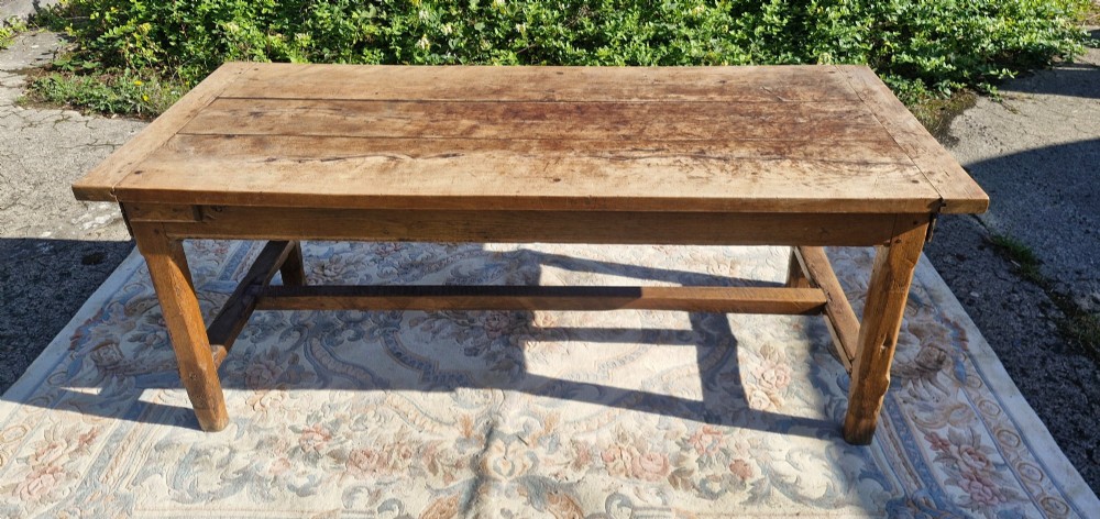 A rustic French farmhouse dining table made of weathered oak with a heavy plank top and sturdy stretcher base. View V